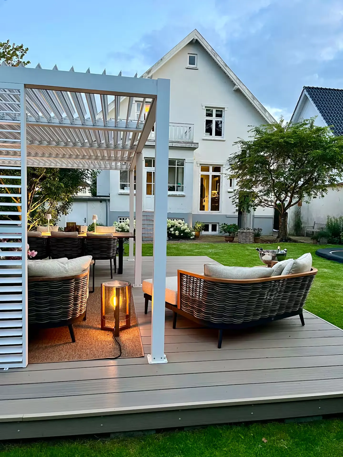 Haven med overdækket terrasse, lounge og villaen i Odense bagved