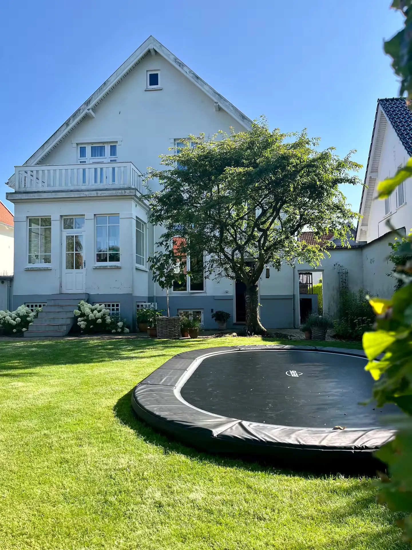 Haven med græsplæne og nedgravet trampolin